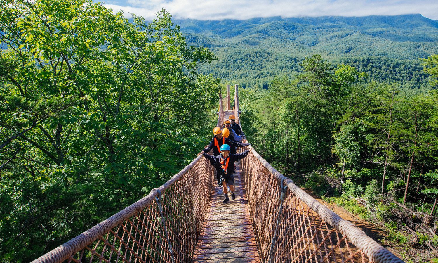 family walking across a skybridge at CLIMB Works Smoky Mountains