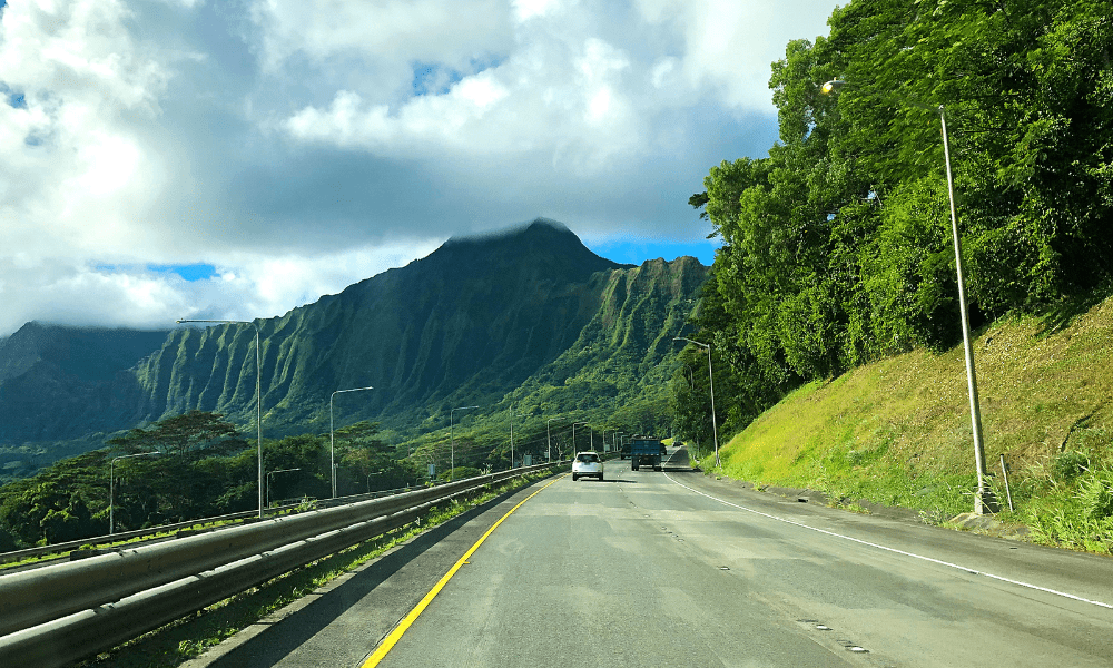road in hawaii looking at a green mountain