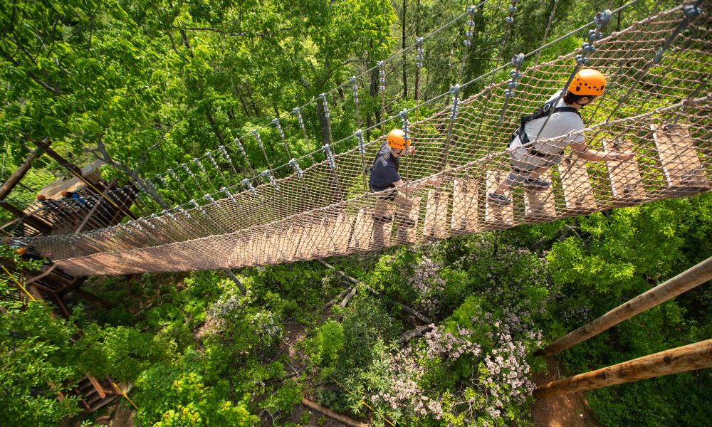 two people on a suspension bridge at climb works smoky mountains