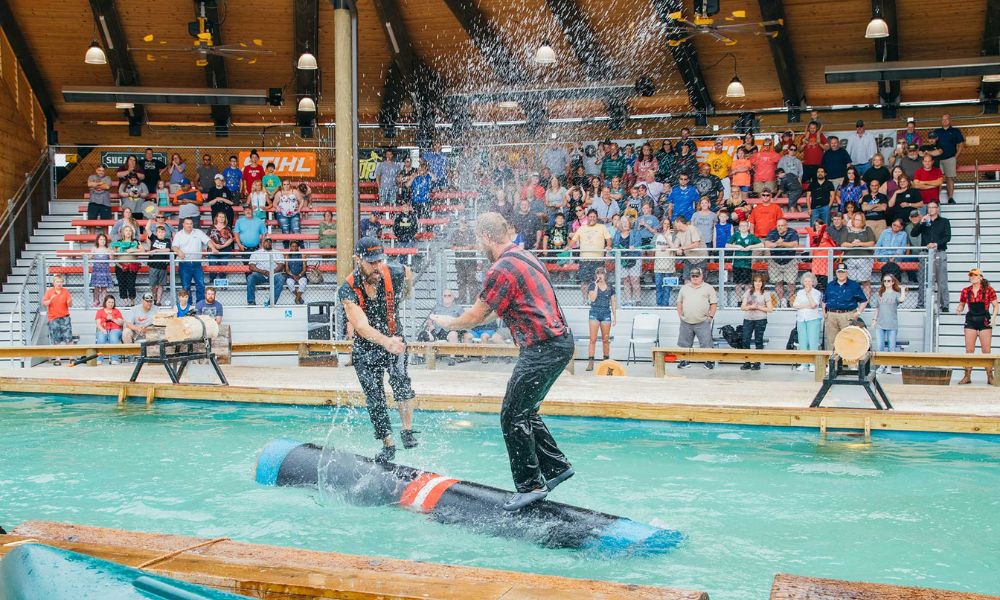 two men on a spinning log in the water at lumberjack feud