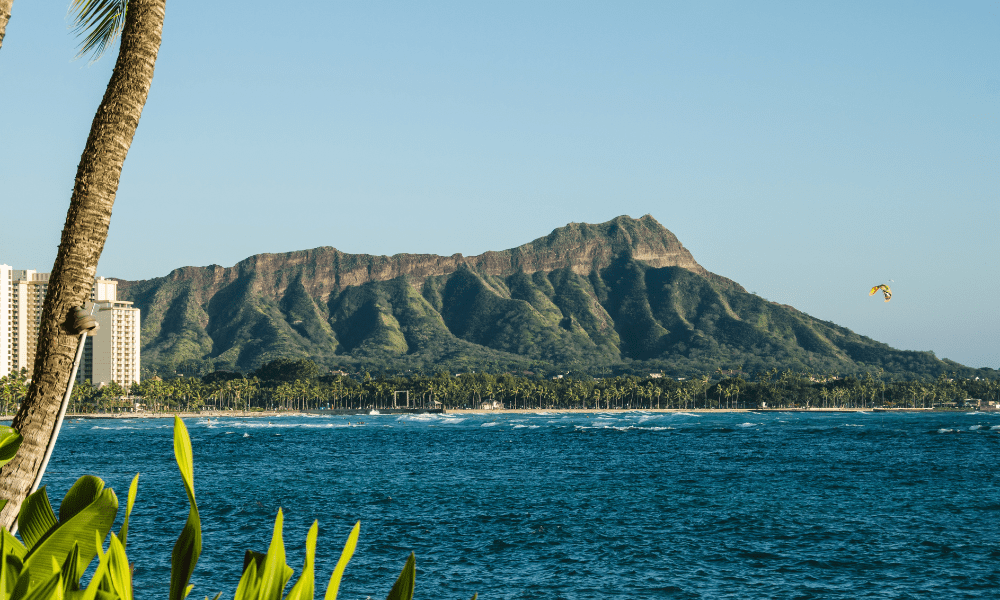 view of diamond head near honolulu, oahu; parasailor over the water in the foreground